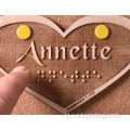 Braille yang disesuaikan dengan logo berbentuk hati kayu